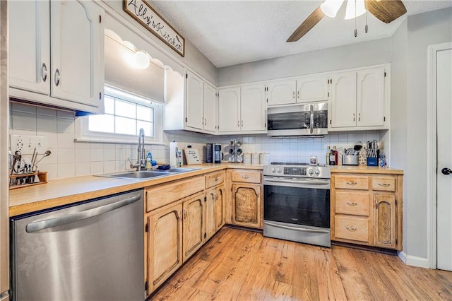 4252 SE Valleyview Ln, Holt, MO 64048 - kitchen featuring appliances with stainless steel finishes, tasteful backsplash, a ceiling fan, light countertops, and light wood-type flooring