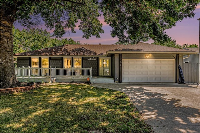 2518 Arrowhead Rd, Topeka, KS 66614 - single story home with concrete driveway, an attached garage, a porch, and brick siding