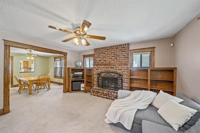 362 S 10th St, Kansas City, KS 66102 - carpeted living area featuring a textured ceiling, ceiling fan, and a brick fireplace