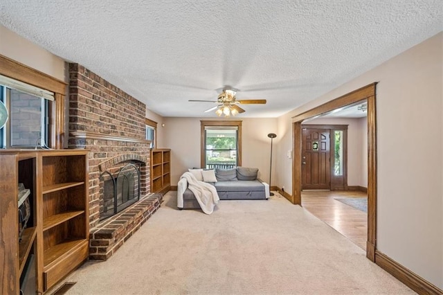 362 S 10th St, Kansas City, KS 66102 - living room with carpet floors, a fireplace, a textured ceiling, and a ceiling fan