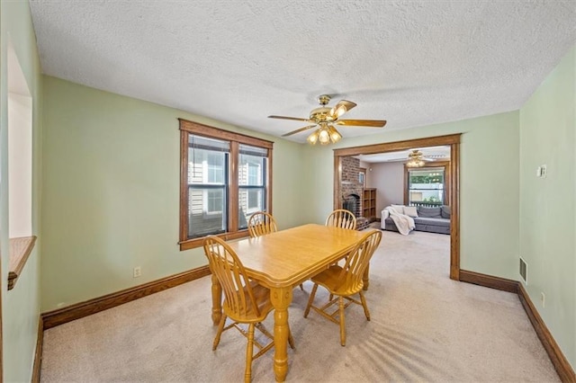 362 S 10th St, Kansas City, KS 66102 - dining room with a ceiling fan, light colored carpet, a brick fireplace, and a textured ceiling