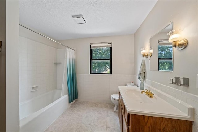 362 S 10th St, Kansas City, KS 66102 - full bathroom featuring vanity, a textured ceiling, tile patterned flooring, shower / bath combo, and tile walls