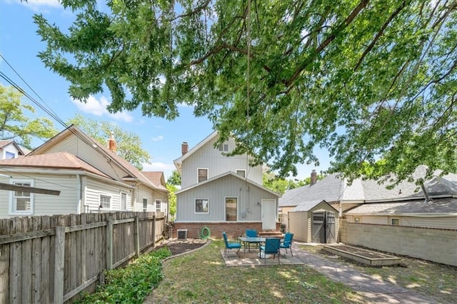 362 S 10th St, Kansas City, KS 66102 - rear view of property with a storage shed, a patio area, a fenced backyard, and brick siding