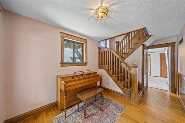 362 S 10th St, Kansas City, KS 66102 - living area with wood finished floors, stairway, and a textured ceiling