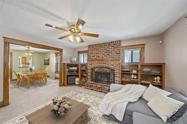 362 S 10th St, Kansas City, KS 66102 - living room with a ceiling fan, a textured ceiling, carpet, and a fireplace