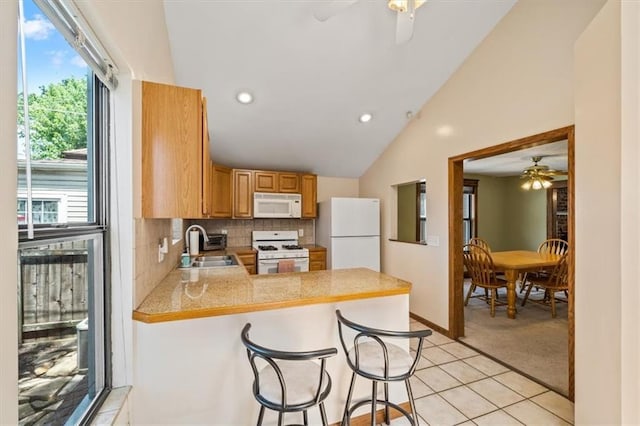 362 S 10th St, Kansas City, KS 66102 - kitchen featuring white appliances, ceiling fan, a peninsula, lofted ceiling, and light carpet