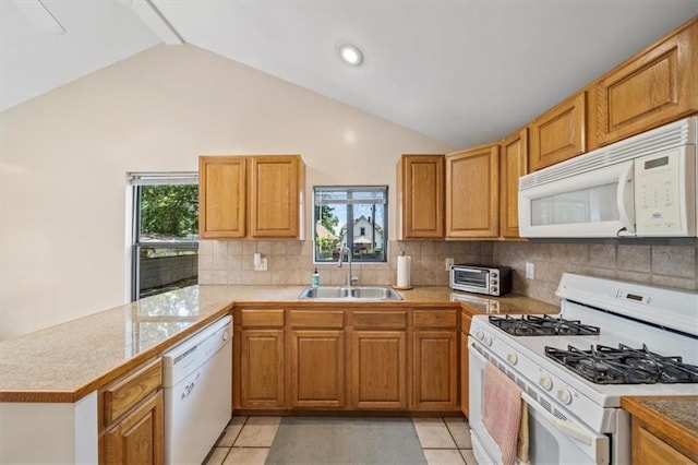 362 S 10th St, Kansas City, KS 66102 - kitchen with white appliances, a peninsula, vaulted ceiling, healthy amount of natural light, and backsplash
