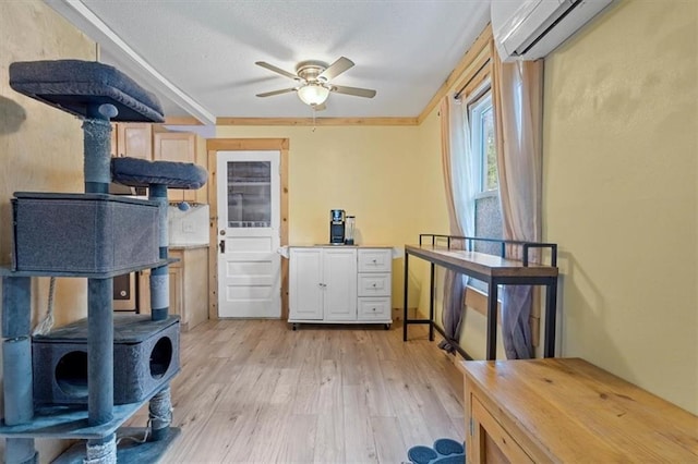 733 S Chestnut St, Olathe, KS 66061 - kitchen featuring a wood stove, a wall unit AC, light wood-style floors, ceiling fan, and a textured ceiling