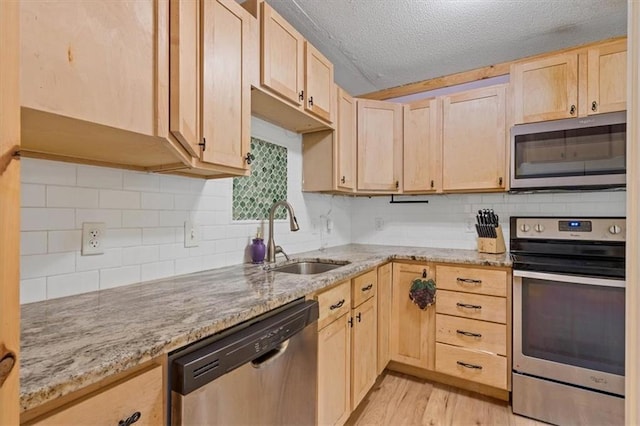 733 S Chestnut St, Olathe, KS 66061 - kitchen with stainless steel appliances, light brown cabinetry, light stone countertops, and a textured ceiling