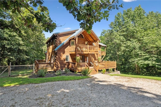389 NW 1851st Rd, Kingsville, MO 64061 - cabin with log exterior, a wooden deck, and a balcony