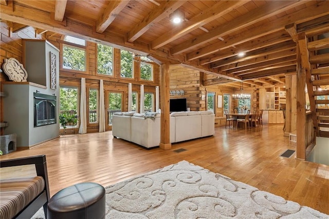 389 NW 1851st Rd, Kingsville, MO 64061 - living room with wood walls, a wooden ceiling with exposed beams, wood finished floors, and a chandelier