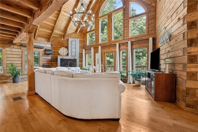 389 NW 1851st Rd, Kingsville, MO 64061 - living room with high vaulted ceiling, wood walls, light wood-type flooring, a chandelier, and a wooden ceiling with exposed beams