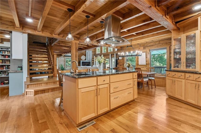 389 NW 1851st Rd, Kingsville, MO 64061 - kitchen featuring a wooden ceiling with exposed beams, island range hood, light brown cabinetry, light wood-style floors, and dark stone counters