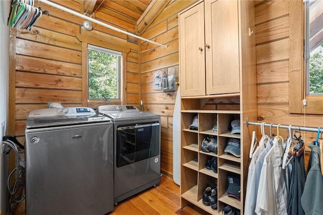 389 NW 1851st Rd, Kingsville, MO 64061 - laundry area with washing machine and clothes dryer, cabinet space, light wood-style floors, wood walls, and wooden ceiling