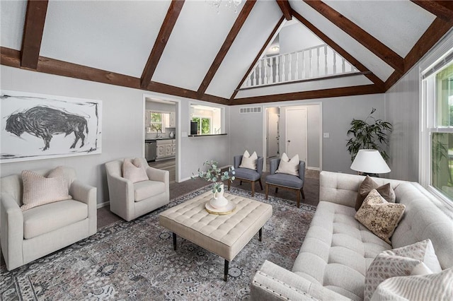 12731 Byars Rd, Grandview, MO 64030 - living area featuring high vaulted ceiling, beam ceiling, healthy amount of natural light, and carpet floors