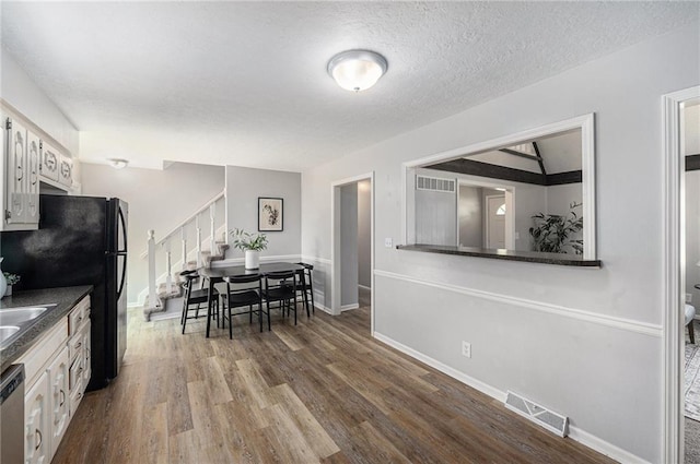 12731 Byars Rd, Grandview, MO 64030 - dining area with stairs, dark wood-type flooring, and a textured ceiling