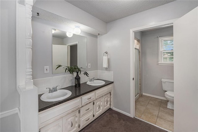 12731 Byars Rd, Grandview, MO 64030 - bathroom featuring a textured ceiling, double vanity, a stall shower, ornate columns, and tile patterned flooring