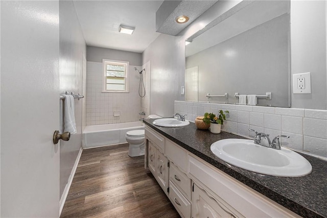 12731 Byars Rd, Grandview, MO 64030 - bathroom with shower / bathtub combination, double vanity, backsplash, and wood finished floors