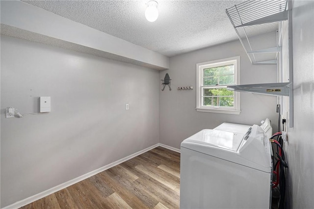 12731 Byars Rd, Grandview, MO 64030 - laundry area with washing machine and dryer, wood finished floors, and a textured ceiling