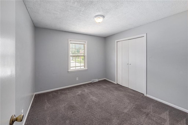 12731 Byars Rd, Grandview, MO 64030 - unfurnished bedroom featuring dark carpet, a closet, and a textured ceiling
