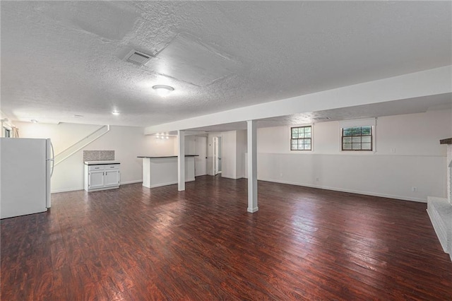 12731 Byars Rd, Grandview, MO 64030 - basement featuring freestanding refrigerator, wood finished floors, and a textured ceiling