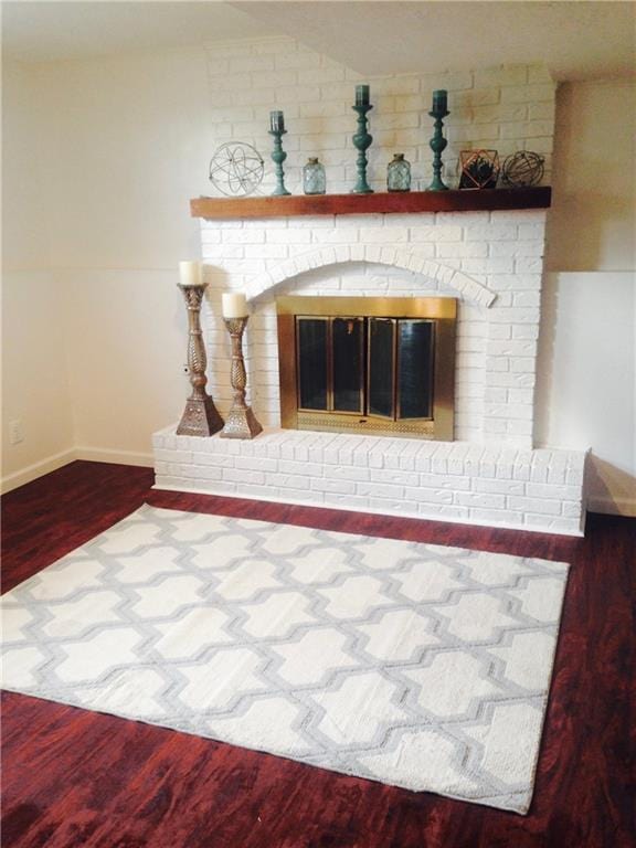 12731 Byars Rd, Grandview, MO 64030 - detailed view of wood finished floors and a brick fireplace