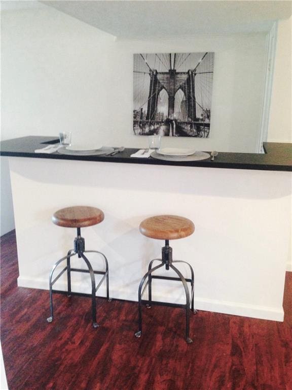 12731 Byars Rd, Grandview, MO 64030 - bar area with wood finished floors and baseboards