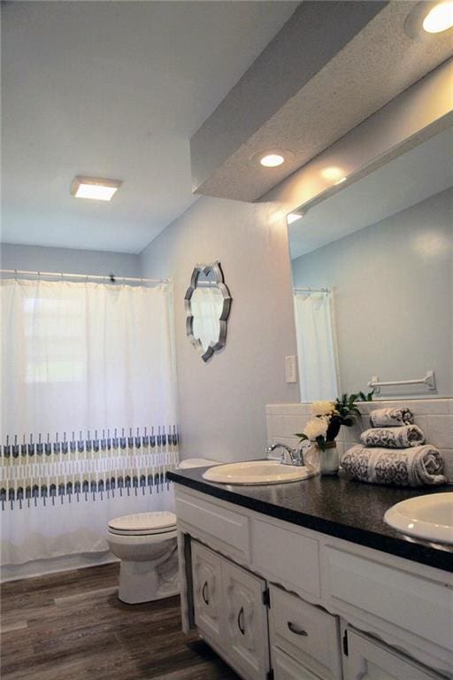 12731 Byars Rd, Grandview, MO 64030 - bathroom with double vanity, wood finished floors, curtained shower, and recessed lighting