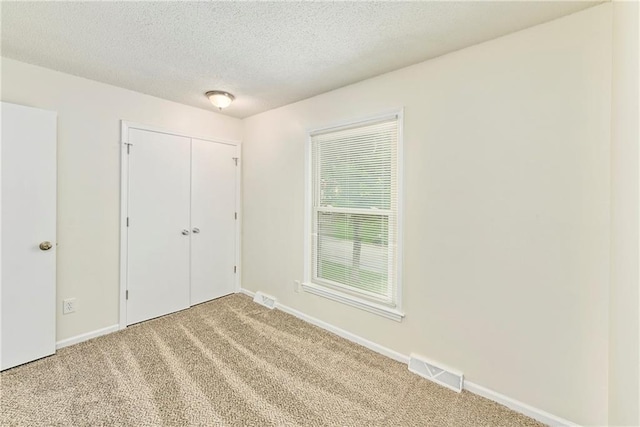 805 NW 18th St, Blue Springs, MO 64015 - unfurnished bedroom featuring carpet floors, a textured ceiling, and a closet