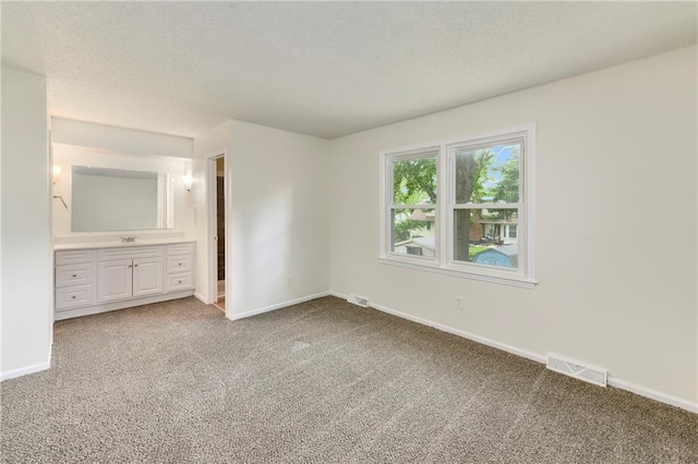 805 NW 18th St, Blue Springs, MO 64015 - unfurnished bedroom featuring carpet, a textured ceiling, and connected bathroom