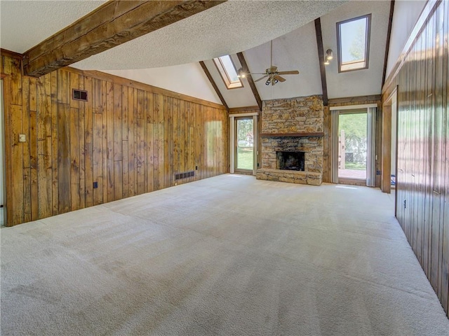4008 NE 57th Ter, Kansas City, MO 64119 - unfurnished living room with a skylight, beamed ceiling, ceiling fan, carpet, and a textured ceiling