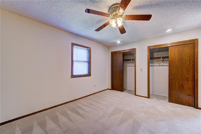 4008 NE 57th Ter, Kansas City, MO 64119 - unfurnished bedroom with two closets, a textured ceiling, carpet flooring, and ceiling fan