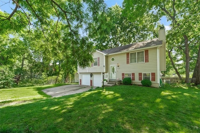 15509 Lawrence Ave, Belton, MO 64012 - raised ranch featuring a chimney, a garage, and driveway