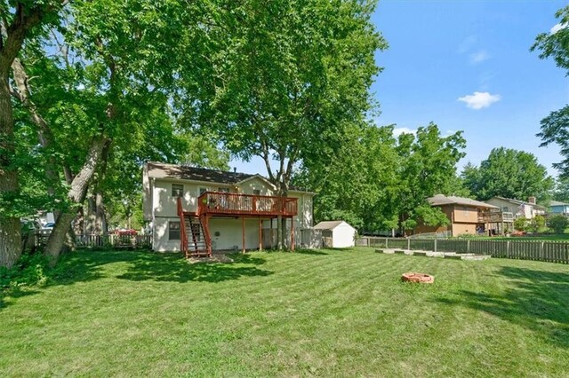 15509 Lawrence Ave, Belton, MO 64012 - fenced backyard featuring stairs, a deck, and a storage unit