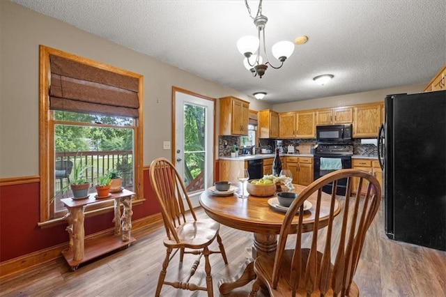 15509 Lawrence Ave, Belton, MO 64012 - dining area featuring a textured ceiling, light wood finished floors, and a chandelier