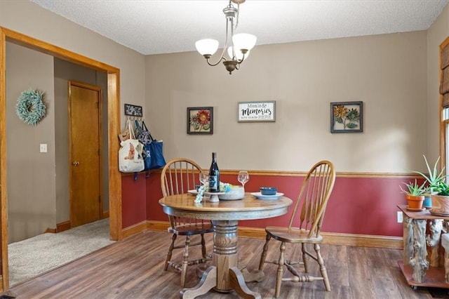 15509 Lawrence Ave, Belton, MO 64012 - dining room featuring wood finished floors, a chandelier, and a textured ceiling