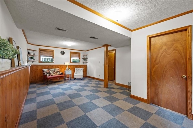 15509 Lawrence Ave, Belton, MO 64012 - interior space featuring a textured ceiling, ornamental molding, dark carpet, a wainscoted wall, and wood walls