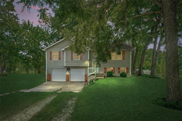 15509 Lawrence Ave, Belton, MO 64012 - split foyer home featuring concrete driveway, an attached garage, a yard, and brick siding