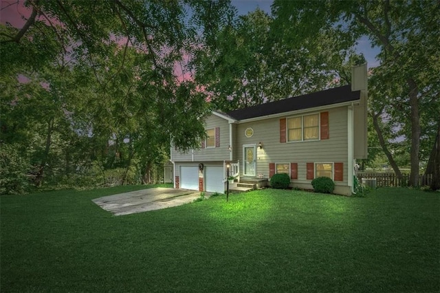 15509 Lawrence Ave, Belton, MO 64012 - back of property with a chimney, a garage, and driveway