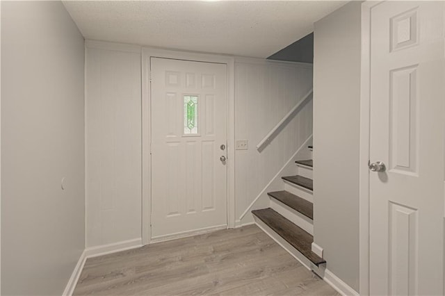 8167 NE 50th St, Kansas City, MO 64119 - foyer entrance with light wood-type flooring, stairs, and a textured ceiling