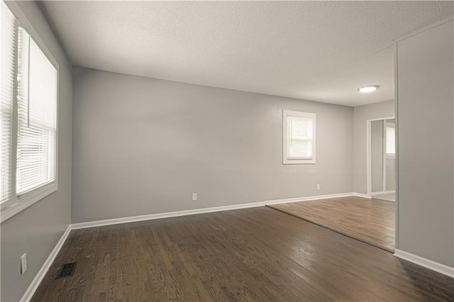 8167 NE 50th St, Kansas City, MO 64119 - spare room featuring dark wood-type flooring and a textured ceiling