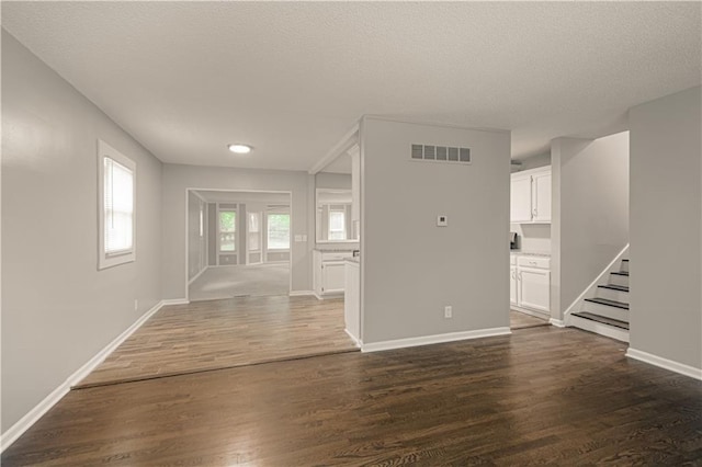 8167 NE 50th St, Kansas City, MO 64119 - unfurnished living room featuring stairway, dark wood-type flooring, and a textured ceiling