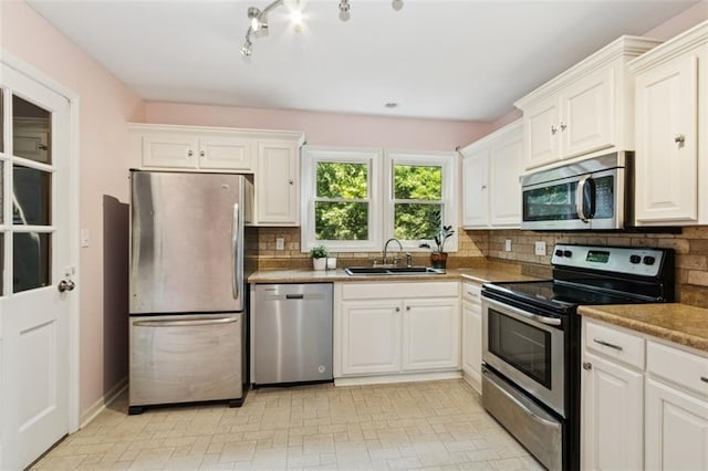 4112 N Hardesty Ave, Kansas City, MO 64117 - kitchen with stainless steel appliances, decorative backsplash, and white cabinetry