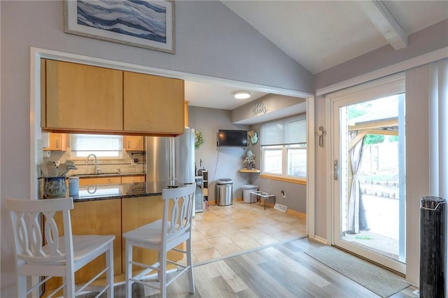 5101 NW Downing St, Blue Springs, MO 64015 - kitchen with lofted ceiling, decorative backsplash, a kitchen breakfast bar, a peninsula, and light wood-type flooring