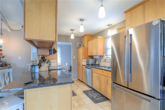 5101 NW Downing St, Blue Springs, MO 64015 - kitchen featuring stainless steel appliances, a peninsula, light brown cabinetry, light tile patterned floors, and dark stone countertops
