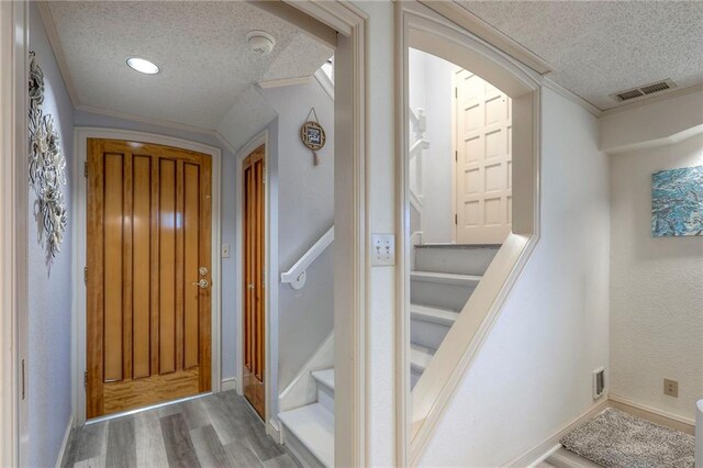 5101 NW Downing St, Blue Springs, MO 64015 - entryway featuring a textured ceiling, arched walkways, wood finished floors, crown molding, and stairs