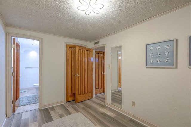 5101 NW Downing St, Blue Springs, MO 64015 - unfurnished bedroom with wood finished floors, a textured ceiling, crown molding, and ensuite bathroom