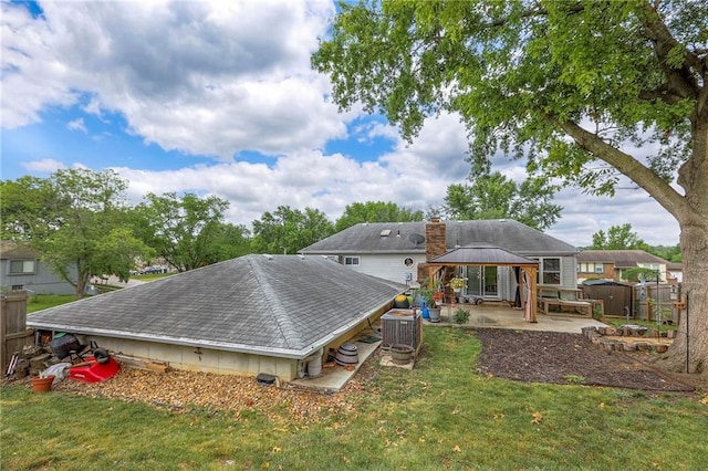 5101 NW Downing St, Blue Springs, MO 64015 - rear view of property featuring a gazebo, a patio, a shingled roof, and a chimney