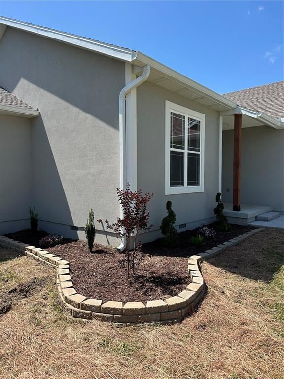 407 N Harmon St, Girard, KS 66743 - view of home's exterior with stucco siding, crawl space, and roof with shingles