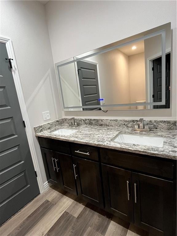 407 N Harmon St, Girard, KS 66743 - full bathroom featuring double vanity and wood finished floors